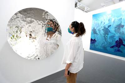 Dubai, United Arab Emirates - Reporter: Alexandra Chaves. Arts and Lifestyle. A visitor looks at a piece by Anish Kapoor called Random Triangle Mirror. Art Dubai 2021 opens at the DIFC. Tuesday, March 30th, 2021. Dubai. Chris Whiteoak / The National