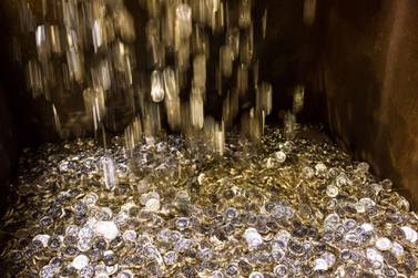 British one pound coins drop into a container during their production at The Royal Mint in Llantrisant, UK. The coinmaker is now melting down one million 50 pence pieces that were minted to mark Britain's exit from the European Union on October 31, which has been delayed by three months. Bloomberg.