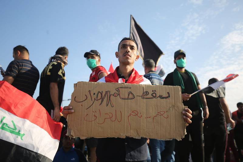 A protestor holds a sign reading in Arabic, "down with the rule of parties, yes, yes for Iraq." AFP