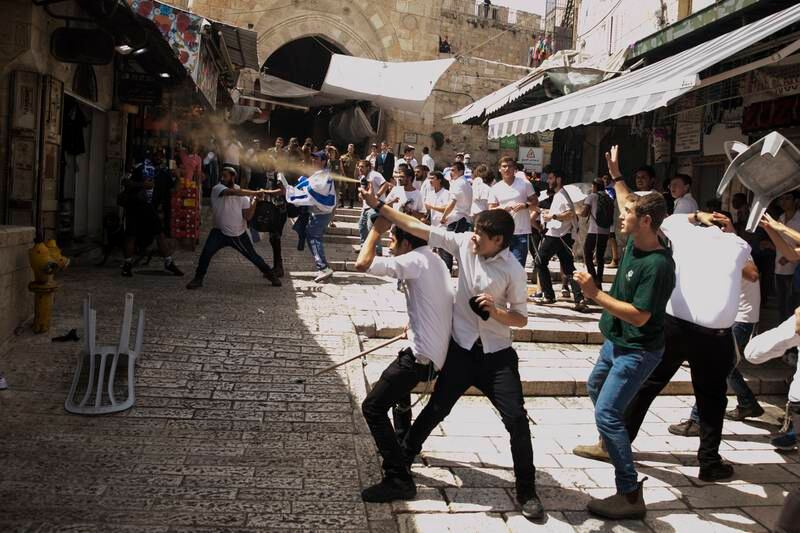 A Jewish youth uses pepper spray on Palestinians as violence flares in Jerusalem. Getty 