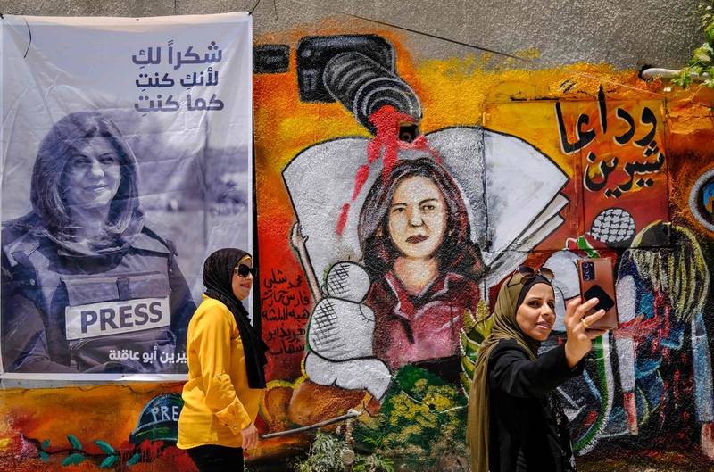 Two women take a selfie on May 19 at an art exhibition honouring Palestinian journalist Shireen Abu Akleh in Jenin city in the occupied West Bank. AFP