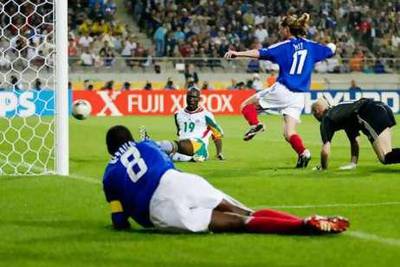 Papa Bouba Diop of Senegal scores the winning goal against France as goalkeeper Fabien Barthez, Emmanuel Petit and a grounded Marcel Desailly of France look on in the 2002 World Cup.