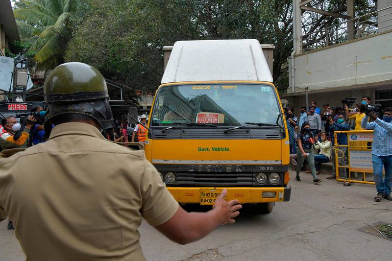 Policemen guard the entrance of the Karnataka Health Department cold storage centre as a vehicle carrying 648,000 vials of Covishield vaccine produced by Pune-based Serum Institute of India (SII) arrives in Bangalore, in preparation for the first round of vaccination drive scheduled to begin across the country from January 16. AFP