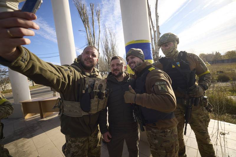 Buoyant Ukrainian soldiers take a selfie with the president in Kherson.