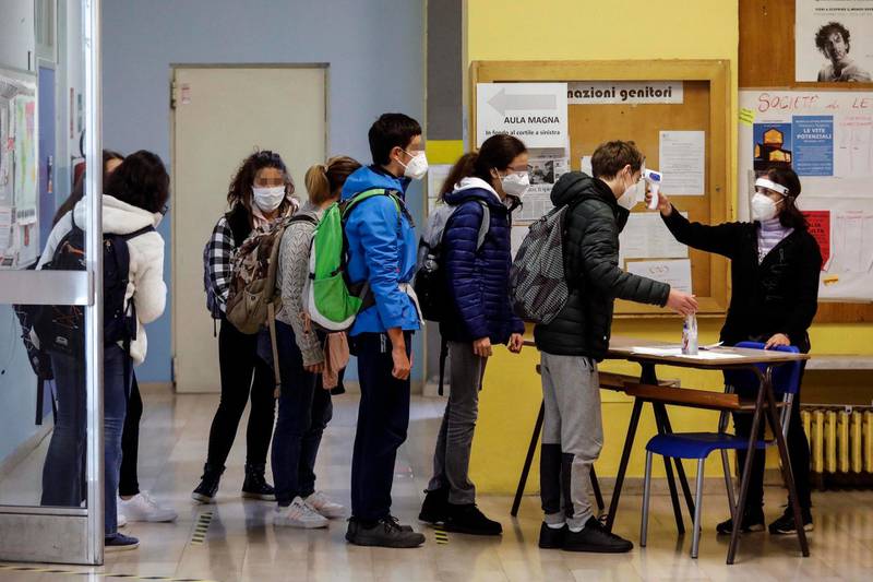 Students have their body temperature checked as they enter the Alessandro Volta high school in Milan, Italy. EPA