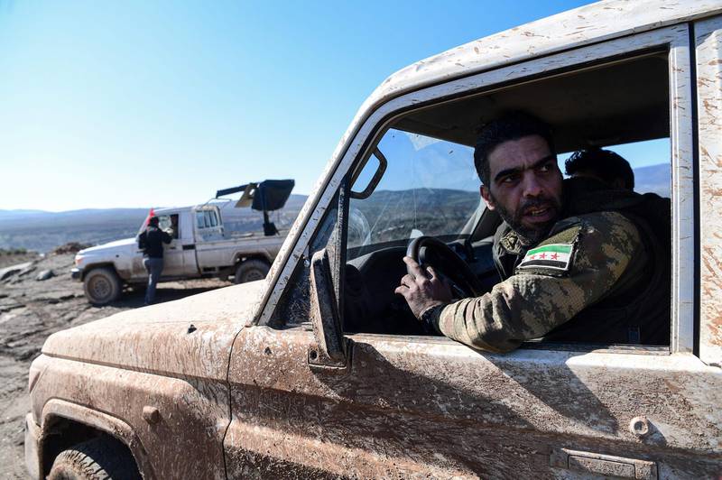 TOPSHOT - Turkish-backed Syrian rebel fighters are seen as they drive toward the Turkish-Syrian border in Kilis, on January 30, 2018, as part ot the operation "Olive Branch" against the Kurdish People's Protection Units (YPG) in Syria, which Turkey considers a "terror" group. 
Authorities in Syria's Kurdish autonomous region said on Sunday they would not attend peace talks in Russia's Sochi next week because of Turkey's offensive against the Kurdish enclave of Afrin.  / AFP PHOTO / OZAN KOSE