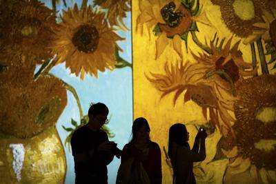 Visitors take photos as paintings by Vincent van Gogh are projected during an exhibition at a shopping mall in Beijing. The 'Van Gogh Alive' exhibit includes over 3,000 images of the Dutch painter's work as part of a multimedia display. Mark Schiefelbein / AP Photo