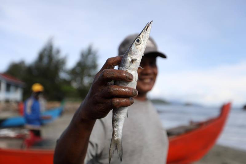 A man shows his catch after fishing in the sea, during a Ramadan morning, in Banda Aceh, Indonesia.  EPA