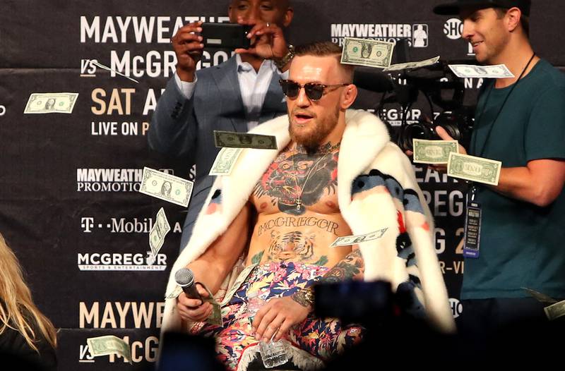 Conor McGregor looks on as money rains down during the Floyd Mayweather Jr. v Conor McGregor world press tour event  on July 13, 2017 in New York City.