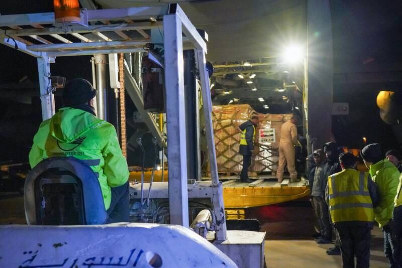 Syrian airport workers begin to unload the food supplies