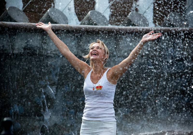 A woman cools off in a fountain in Alexander Garden near the Kremlin Wall in Moscow, Russia. AP