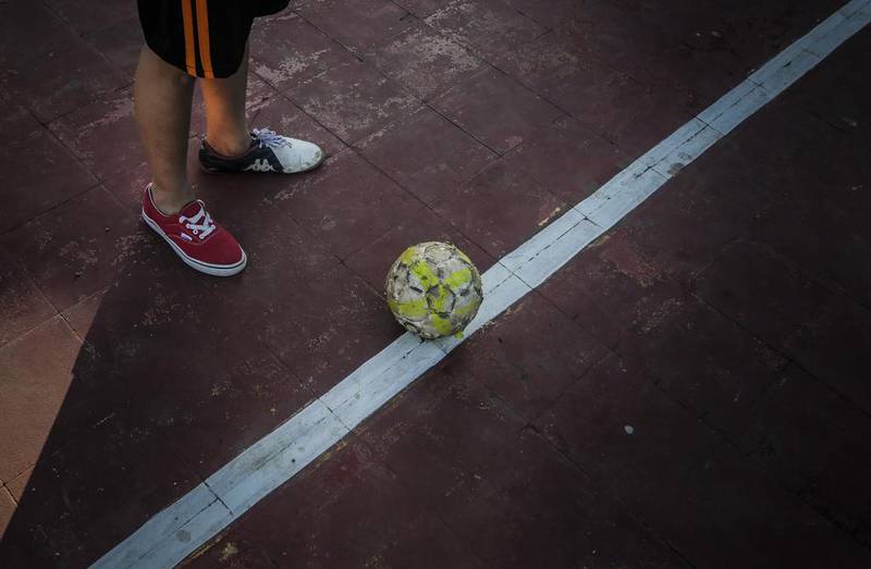 A boy wearing different shoes plays football in a neighbourhood of Managua, on January 13, 2016. Football is gaining enthusiasts in Nicaragua where baseball has been historically dominant but is now giving way to the new sport, analysts said. Inti Ocon / AFP