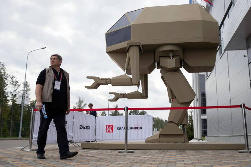 A visitor passes a model of a guided robot-style system presented by the Concern Kalashnikov during the International Military Technical Forum Army-2018 in Alabino, outside Moscow, Tuesday, Aug. 21, 2018. Russia has displayed its latest weapons at a military show aimed at attracting more foreign customers. (AP Photo/Pavel Golovkin)