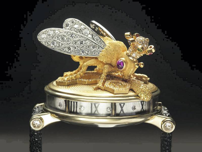 The Queen Bee watch for the Dowager Queen of Morocco is executed in textured 18K yellow gold, the body is decorated with canary yellow diamonds and the wings encrusted with white diamonds. The bee has ruby cabochon eyes, wears a multi-gem-encrusted crown and hovers over yellow and white pave diamond honey cells, by gemstone artist Andreas von Zadora-Gerlof