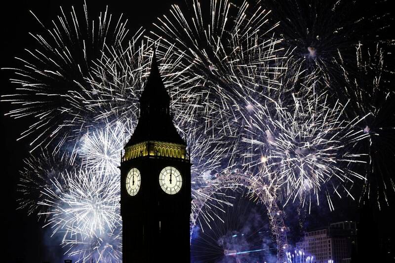 Fireworks illuminate the Elizabeth Tower, part of the Houses of Parliament, and the London Eye in central London during New Year celebrations, on January 1, 2023. PA via AP