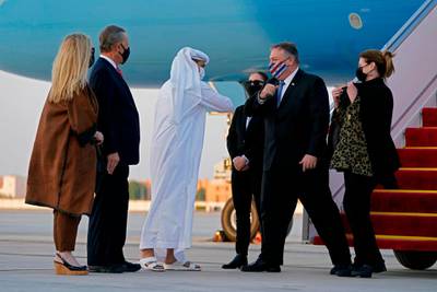 UAE's Protocol Chief Shihab al-Faheem greets with an elbow-bump US Secretary of State Mike Pompeo (C-R) alongside his wife Susan (R) in the presence of US Ambassador to the United Arab Emirates John Rakolta (L) and his wife Terry, at al-Bateen Executive Airport in Abu Dhabi on November 20, 2020.  / AFP / POOL / Patrick Semansky
