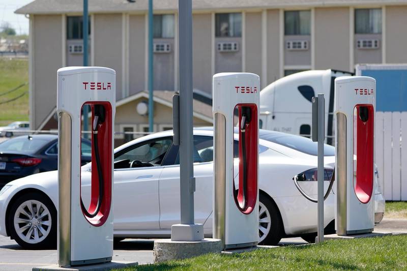 FILE - In this Monday, April 5, 2021 file photo, a Tesla electric vehicle charges at a station in Topeka, Kan. With strong sales of its electric cars and SUVs, Tesla on Monday, April 26, 2021 posted its seventh-straight profitable quarter. (AP Photo/Orlin Wagner)
