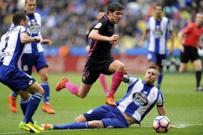 Barcelona’s Sergi Roberto, centre, drives the ball past Deportivo’s Raul Albentosa. Paulo Duarte / AP Photo