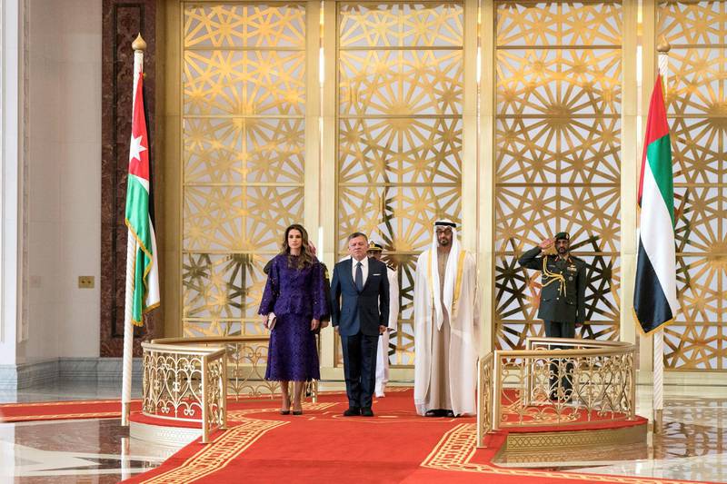 ABU DHABI, UNITED ARAB EMIRATES - February 07, 2018: HH Sheikh Mohamed bin Zayed Al Nahyan Crown Prince of Abu Dhabi Deputy Supreme Commander of the UAE Armed Forces (R) and HM King Abdullah II, King of Jordan (C), stand for the national anthem during a reception at the Presidential Airport. Seen with HM Queen Rania Al Abdullah Queen of Jordan (L).

( Hamad Al Kaabi / Crown Prince Court - Abu Dhabi )
—