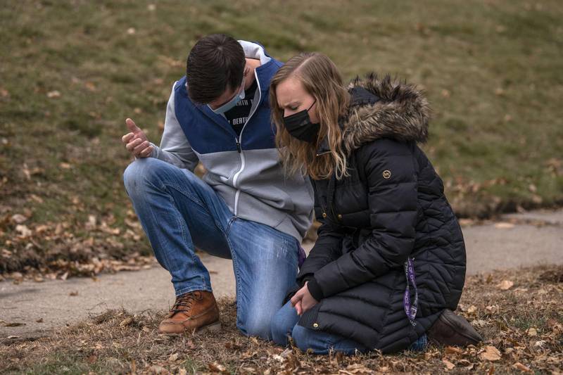 A couple kneel and pray as a group of counter protesters arrive to face off with conservative protesters rallying near the Governor's Mansion in St Paul, Minnesota. People gathered to demand a response from Governor Tim Walz and protest the state's coronavirus lockdown measures and the results of the recent presidential election.  AFP