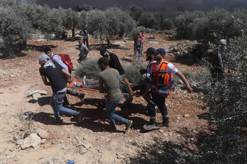 Palestinian medics evacuate a wounded  protester during clashes after a demonstration against the expansion of the new Jewish outpost of Eviatar on the lands of Beita village near the West Bank City of Nablus, July 9. EPA