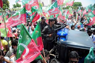 Security guards of cricket legend and (PTI) Movement for Justice party leader Imran Khan keep watch during a campaign rally in Karachi.