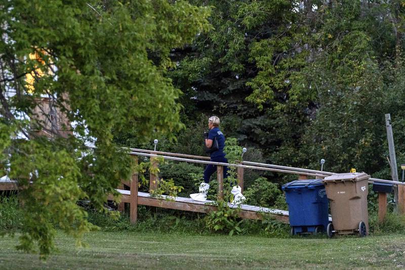 A coroner enters a house at the scene of a stabbing in Weldon, Saskatchewan. AP
