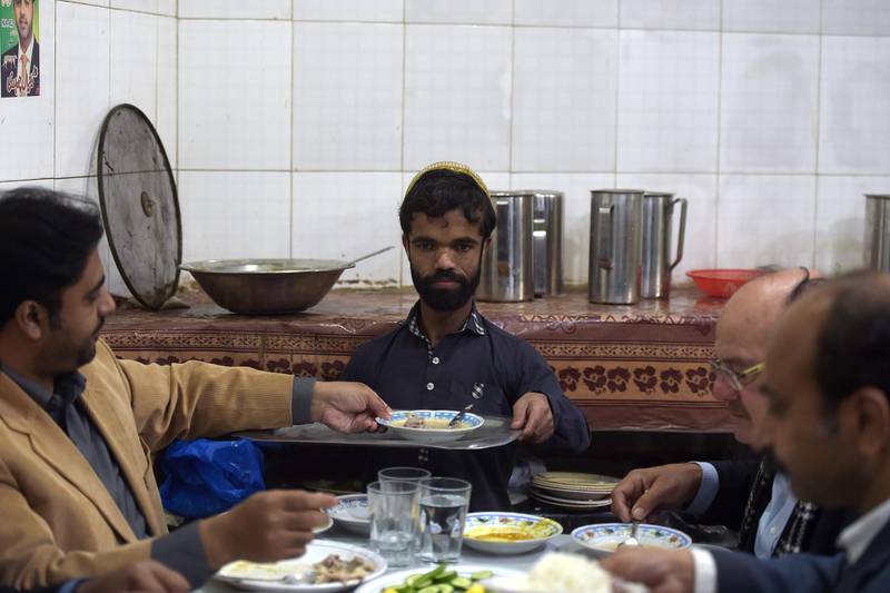 Rozi Khan serves food to customers at Dilbar Hotel in Rawalpindi. AFP