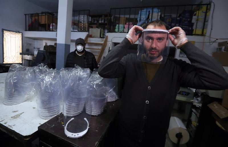 Tunisian Mohamed Amine Ben Gharbia owner of a 3D printer tries a mask at his workshop in Bizerte, 60kms north of Tunis.  EPA