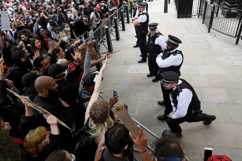 A police officer takes a knee in front of protesters near Downing Street during a "Black Lives Matter" protest following the death of George Floyd who died in police custody in Minneapolis, London, Britain. REUTERS