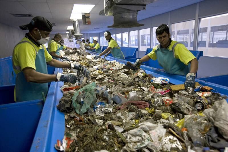 Workers sift through the rubbish from the Sharjah landfill to separate the recyclables. Jeff Topping / The National