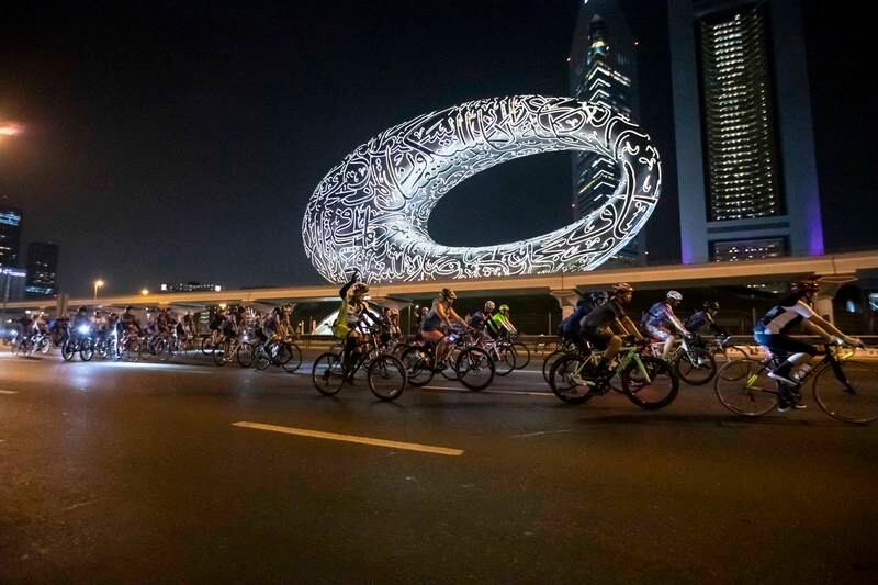 Participants cycle past the Museum of the Future in the early hours of Sunday. 