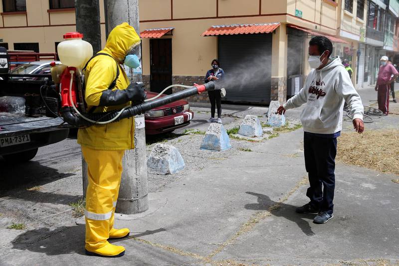 A health worker sprays disinfectant on a man in Quito, Ecuador. Ecuador recently moved past 100,000 confirmed cases of Covid-19. EPA