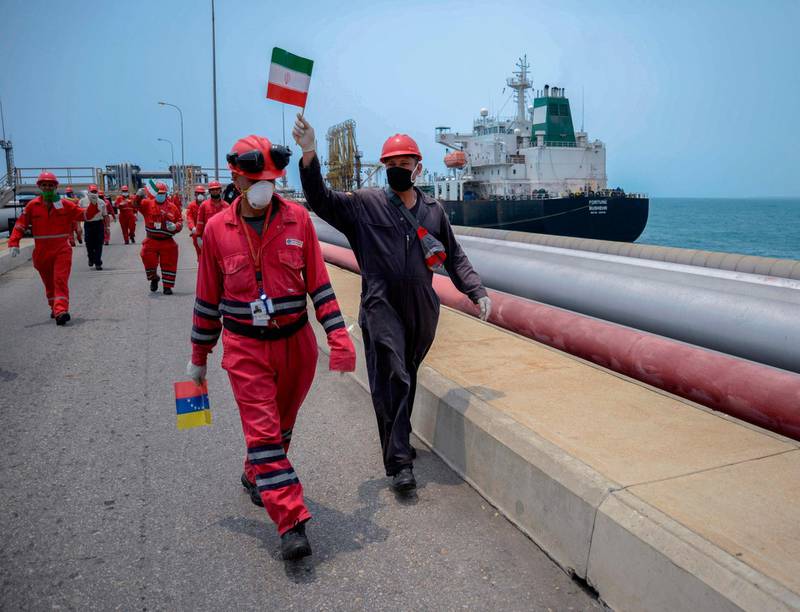 A worker of the Venezuelan state oil company PDVSA waves an Iranian flag as the Iranian-flagged oil tanker Fortune docks at the El Palito refinery in Puerto Cabello, in the northern state of Carabobo, Venezuela.  AFP