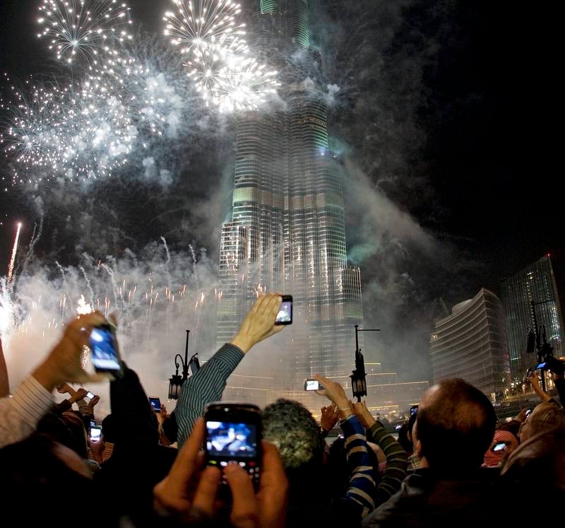 Dubai, December 31, 2010 - Spectators photograph the fireworks at the Burj Khalifa on New Year's Eve in Dubai, December 31, 2010. (Jeff Topping/The National) 