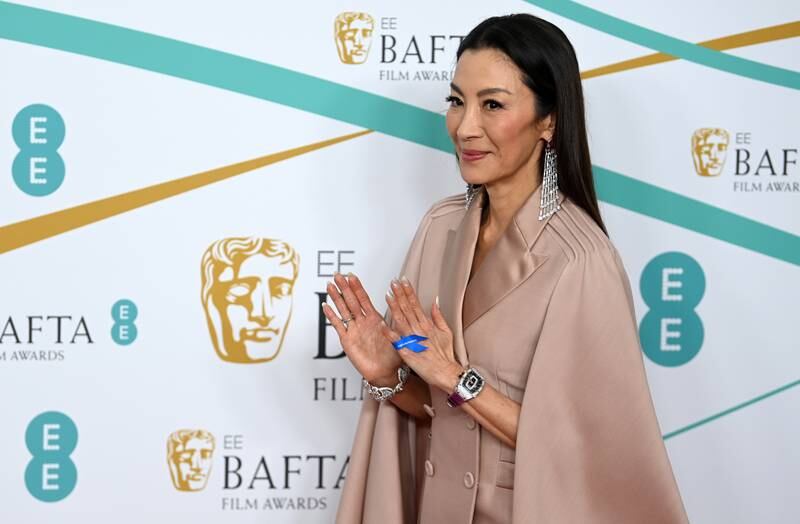 Actress Michelle Yeoh wears a #WithRefugees ribbon on her hand at the Baftas. EPA