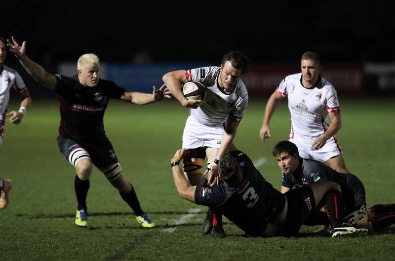 An Abu Dhabi Harlequins player attempts to beat a tackle from a Dubai Exiles opponent.