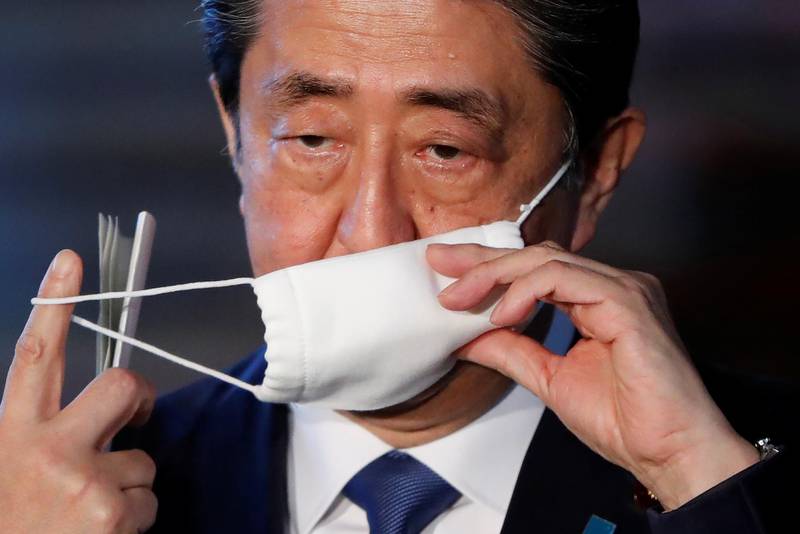 Japan's Prime Minister Shinzo Abe takes off his face mask as he arrives to speak to the media on Japan's response to the coronavirus disease (COVID-19) outbreak, at his official residence in Tokyo, Japan, April 6, 2020. REUTERS/Issei Kato