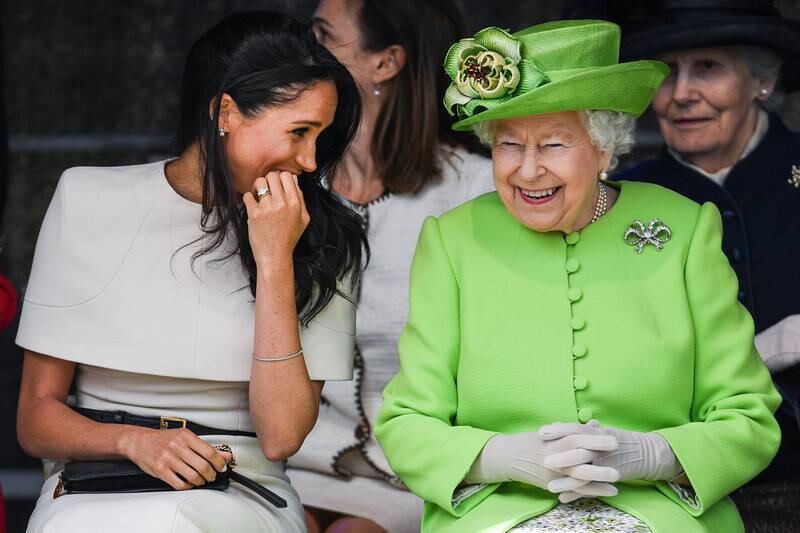 Queen Elizabeth sits and laughs with Meghan during a ceremony to open the new Mersey Gateway Bridge in Cheshire, in June 2018. Getty Images
