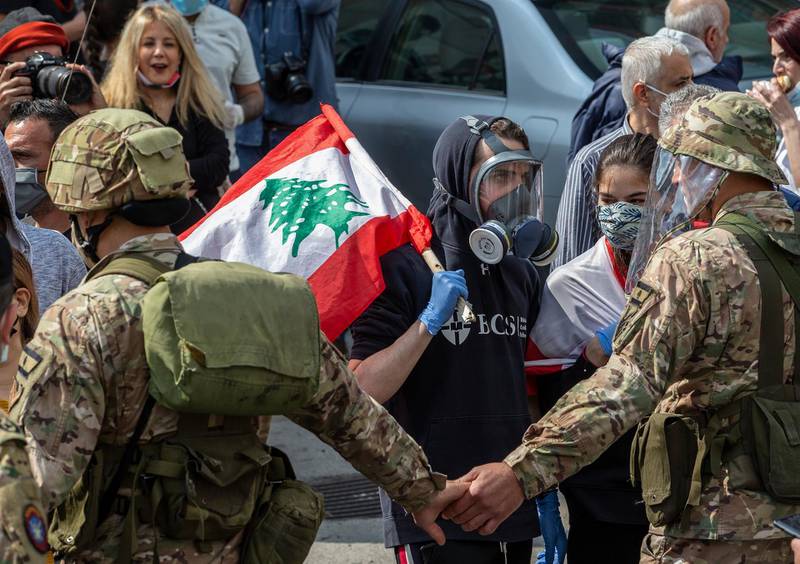 Lebanese army soldiers scuffle with supporters of Lebanese Christians parties where they try to open the Northern Highway during a protest against the collapsing Lebanese pound currency and the price hikes of goods, in Al-Zouk area, northern Beirut, Lebanon.  EPA