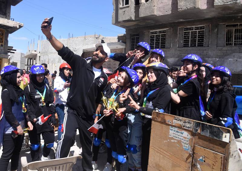 Iraqi female cyclists and their coach pose for a selfie after taking part in the first all-female Mosul cycle race. All participants received medals. EPA