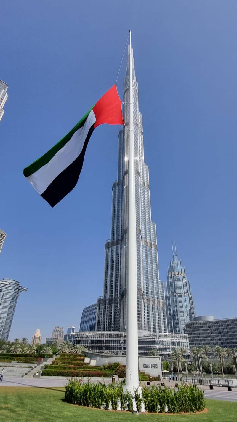 A flagpole holding the UAE flag made by Trident Support and Fabtech International in Burj Park, facing Burj Khalifa.