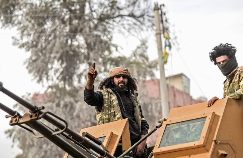 Turkish-backed Syrian Arab fighters stand on an armed vehicle after seizing control of the northwestern Syrian city of Afrin from the Kurdish People's Protection Units (YPG) on March 18, 2018.
In a major victory for Ankara's two-month operation against the Kurdish People's Protection Units (YPG) in northern Syria, Turkish-led forces pushed into Afrin apparently unopposed, taking up positions across the city. / AFP PHOTO / BULENT KILIC