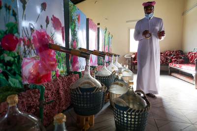 A Bin Salman farm worker checks bottles as they fill with rose water from distillers. AFP