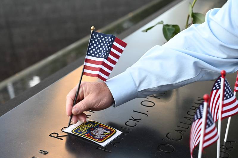 A 9. 11 Memorial staff member places a flag at the South Tower  before ceremonies marking the 20th anniversary of the 9. 11 attack at the World Trade Center in New York which killed almost 3,000 people.  AFP
