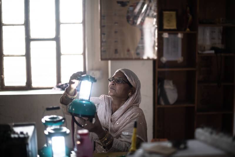 A villager inspects a solar lamp as part of a project to bring solar-powered lighting to rural areas in Tilonia, India. Getty