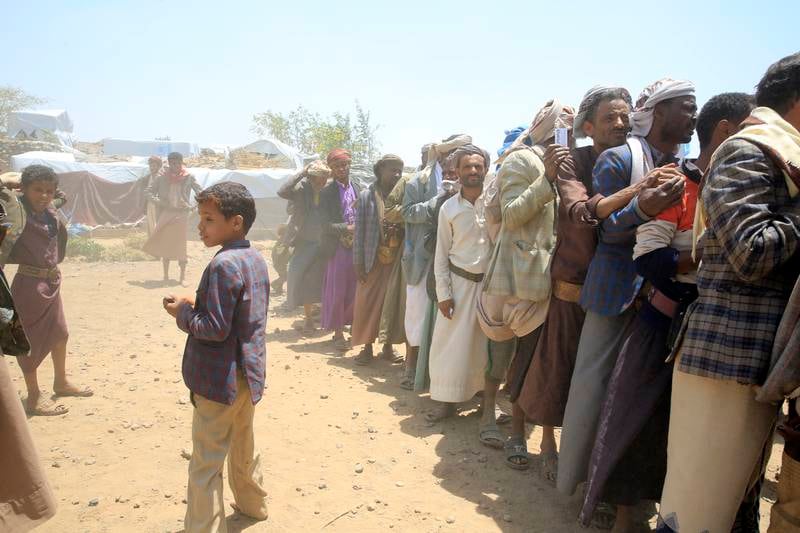Yemenis queue for aid provided by the UN Children's Fund at a camp for displaced people on the outskirts of Sanaa. EPA