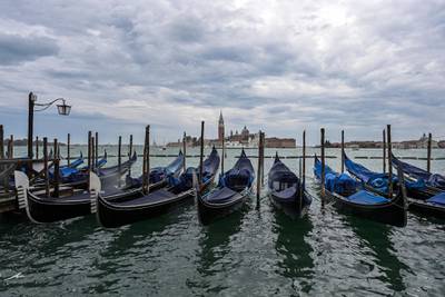 Gondolas are moored in the Venice lagoon on October 3, 2020 as a high tide "Alta Acqua" phenomenon is expected, following a peak of water following bad weather and potential intense sirocco winds along the entire Adriatic basin. - The rise in water levels, expected to peak at midday on October 3, 2020, should be limited by a new system of mobile gates. The MOSE project (Moses in Italian, Electromagnetic Experimental Module) is a complex engineering system allowing the "waterproofing" of Venice through 78 dikes placed at the lagoon's entry points. (Photo by MIGUEL MEDINA / AFP)