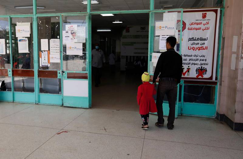 Yemenis pass an anti-coronavirus awareness banner at the entrance to a hospital amid the coronavirus COVID-19 pandemic, in Sanaa. EPA