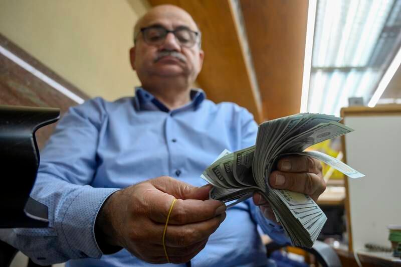 A trader counts US dollars at a currency exchange shop in Beirut. The Lebanese pound has tanked against the US dollar, rendering its peg to the greenback obsolete. EPA